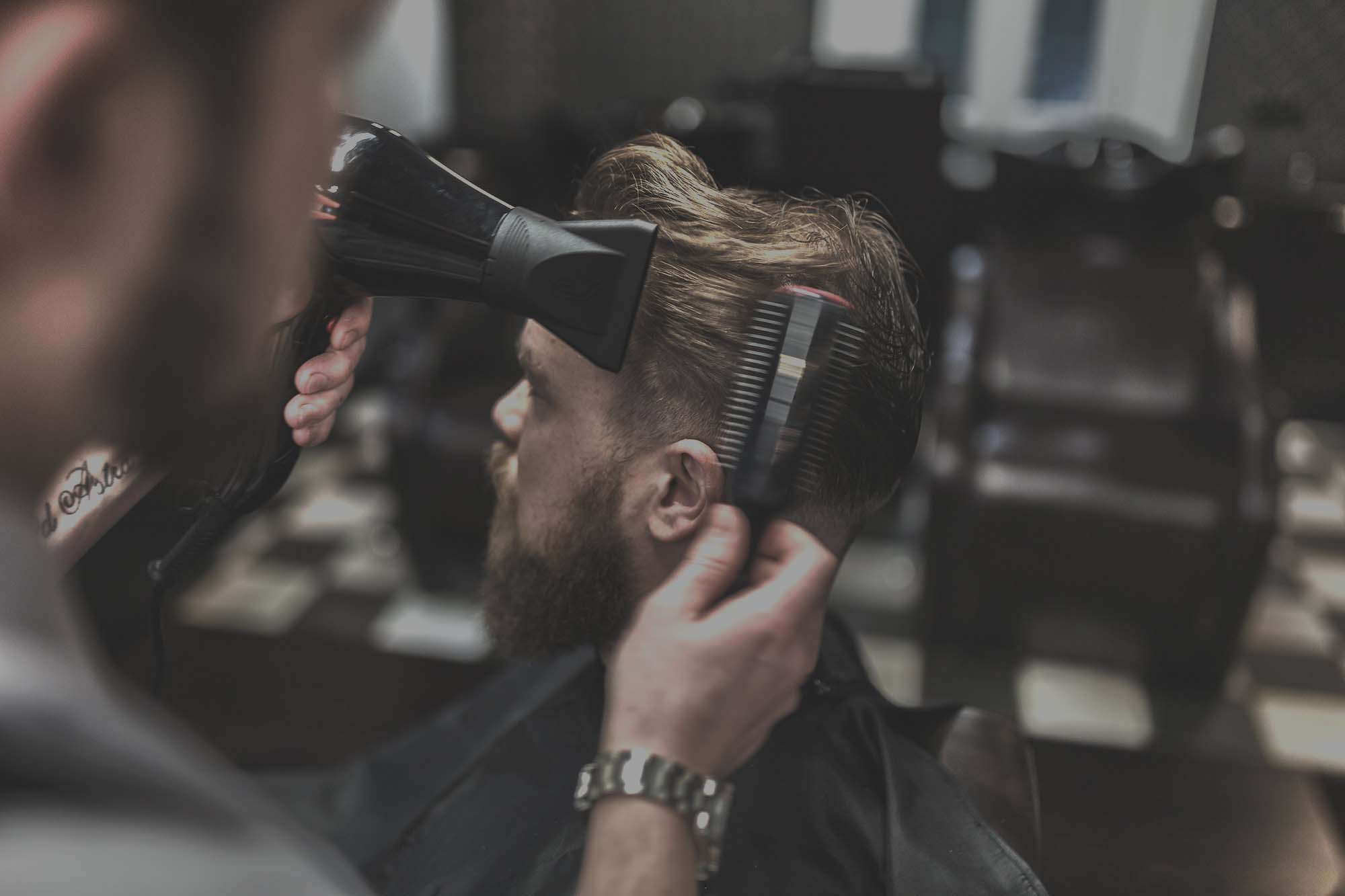 Ein Mann erhält einen professionellen Haarschnitt im Monalisa Barber Shop, der perfekt zu seinem Gesicht passt.